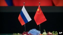 资料照片-北京人民大会堂举行签字仪式上，桌上摆着俄罗斯国旗(左）和中国国旗。 （2018年6月8日）