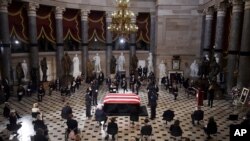 Miembros del Congreso e invitados presentan sus respetos mientras el ataúd cubierto con la bandera de EE.UU. de la jueza Ruth Bader Ginsburg yace en capilla ardiente en el Capitolio, el 25 de septiembre de 2020, en Washington. (Olivier Doul