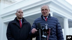El líder de la mayoría en el Senado, Chuck Schumer, habla con reporteros junto al líder de la minoría en la Cámara de Representantes, Hakeem Jeffries, también en el exterior de la Casa Blanca, el 17 de enero, luego de reunirse con el presidente Joe Biden.
