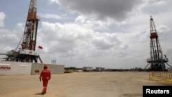 Archivo. Un trabajador de un campo petrolero camina junto a las plataformas de perforación en un pozo petrolero operado por la petrolera estatal venezolana PDVSA, en la rica franja petrolera del Orinoco, el 16 de abril de 2015.