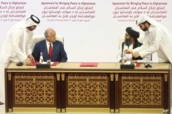 En esta foto de archivo del 29 de febrero de 2020, el enviado de paz de Estados Unidos, Zalmay Khalilzad, a la izquierda, y el mulá Abdul Ghani Baradar, el principal líder político del grupo talibán, firman un acuerdo de paz.