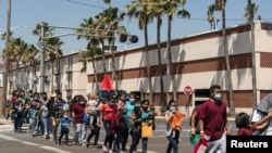 Familias de inmigrantes marchan hacia un albergue temporal en McAllen, Texas, EE. UU., el 8 de abril de 2021.
