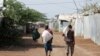 FILE - Men carry bags of food aid at the Kakuma refugee camp in northern Kenya, March 6, 2018. 