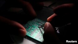 2016年2月29日，中国北京清华紫光研究人员在显微镜下将半导体制品放置到接口板上
