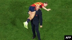 This picture taken on August 20, 2023 shows President of the Royal Spanish Football Federation Luis Rubiales carrying Spain's Athenea del Castillo Beivide on his shoulder as they celebrate winning the Australia and New Zealand 2023 Women's World Cup final