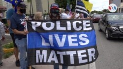 Una mujer sostiene una bandera con el mensaje "La vida de los policías importan" en inglés. Foto: [Antoni Belchi,VOA]