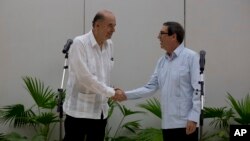 El canciller cubano Bruno Rodríguez, a la derecha, recibe a su contraparte de Colombia, Álvaro Leyva, en La Habana, Cuba, el jueves 11 de agosto de 2022. (AP Foto/Ismael Francisco)