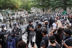 Agentes de policía hacen guardia mientras los manifestantes participan en una protesta cerca de la Casa Blanca contra la muerte en la custodia policial de George Floyd en Minneapolis, en Washington, DC, EE. UU., 1 de junio de 2020.