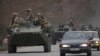 Militares ucranianos sentados encima de vehículos blindados de transporte de personal que conducen por una carretera en la región de Donetsk, en el este de Ucrania, el 24 de febrero de 2022.