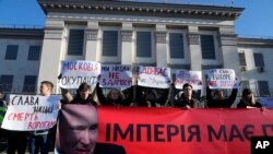 Manifestantes protestan con carteles frente a la embajada de Rusia en Kiev el 22 de febrero de 2022 a la decisión del Kremlin de reconocer a las regiones separatistas de Donbas y Luhansk.