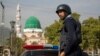 ARCHIVO - Un oficial de policía pakistaní monta guardia fuera del santuario de Barri Imam, mientras se intensifica la seguridad en la capital luego de un ataque suicida en un santuario sufí en Sindh, Islamabad, Pakistán.