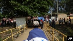 Un migrante centroamericano de Honduras viste la bandera de su nación durante la caravana anual de Migrantes de la Cruz o "Viacrucis", organizada por el grupo activista "Pueblo Sin Fronteras".