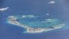 FILE - Chinese dredging vessels are purportedly seen in the waters around Mischief Reef in the disputed Spratly Islands in the South China Sea in this still image taken from video provided by the U.S. Navy, May 21, 2015.