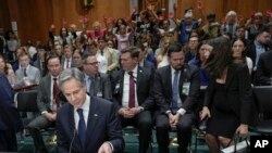 Activistas pro-palestinos (al fondo) protestan contra el secretario de Estado, Antony Blinken, durante audiencia en el Comité de Relaciones Exteriores del Senado en Washington el 21 de mayo de 2024.
