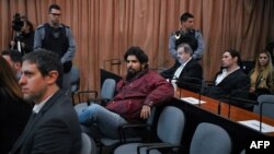 Fernando Sabag Montiel (Centro) y Nicolás Carrizo (derecha), dos de los acusados ​​del intento de asesinato de la exvicepresidenta argentina Cristina Fernández de Kirchner, asisten al juicio en el juzgado de Comodoro Py en Buenos Aires el 26 de junio de 2024.