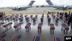 Los ataúdes cubiertos con la bandera de EE.UU. conteniendo los restos de 55 soldados estadounidenses son vistos a su arribo a la base Pearl Harbor-Hickman, en Honolulu, Hawái, el miércoles, 1 de agosto de 2018.