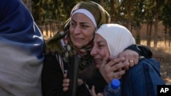 ARCHIVO - Dos mujeres cuyos familiares fueron encarcelados se abrazan afuera de la infame prisión militar de Sednaya, al norte de Damasco, Siria, el 9 de diciembre de 2024. 