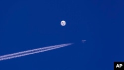 Un avión de combate vuela cerca del globo que se desplazaba sobre el Océano Atlántico, frente a la costa de Carolina del Sur el sábado 4 de febrero de 2023. Poco después el globo fue alcanzado por un misil de un avión de combate.