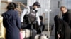 Un policía conversa con una familia que intenta cruzar sin la documentación necesaria la frontera suroeste de Canadá, en marzo pasado. Ese país anunció un programa migratorio con fines humanitarios para beneficiar a 11.000 venezolanos, colombianos y haitianos.