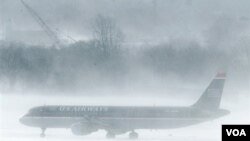 En el aeropuerto de Filadelfia un avión de U.S. Airways aguarda en medio de la nevisca. Muchos pasajeros debieron esperar dentro de los aviones.