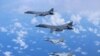 日本自卫队的F-15战机（下面两架）与美国空军B-1B枪骑兵轰炸机在日本上空举行联合军演。（2017年9月9日）