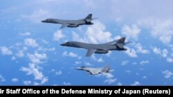 日本自卫队的F-15战机（下面两架）与美国空军B-1B枪骑兵轰炸机在日本上空举行联合军演。（2017年9月9日）