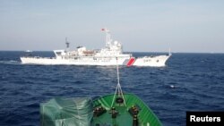 资料照 - 在离越南海岸210公里的南中国海上，从一艘越南海岸警卫队的船上看附近的中国海警船。（2014年5月14日）