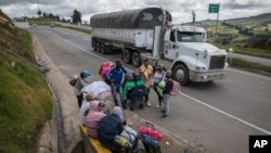Los migrantes venezolanos descansan mientras caminan hacia Bogotá, en Tunja, Colombia, el martes 6 de octubre de 2020.
