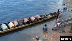 Archivo - Un indígena prepara su canoa para transportar barriles de gas a la zona minera cerca de la población de Parpupik, en el sur de Venezuela, el 16 de noviembre de 2012.