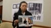 李明哲的妻子李净瑜向媒体展示李明哲以往活动的照片(美国之音杨明拍摄) 
