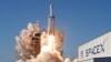 A SpaceX Falcon Heavy rocket, carrying the Arabsat 6A communications satellite, lifts off from the Kennedy...